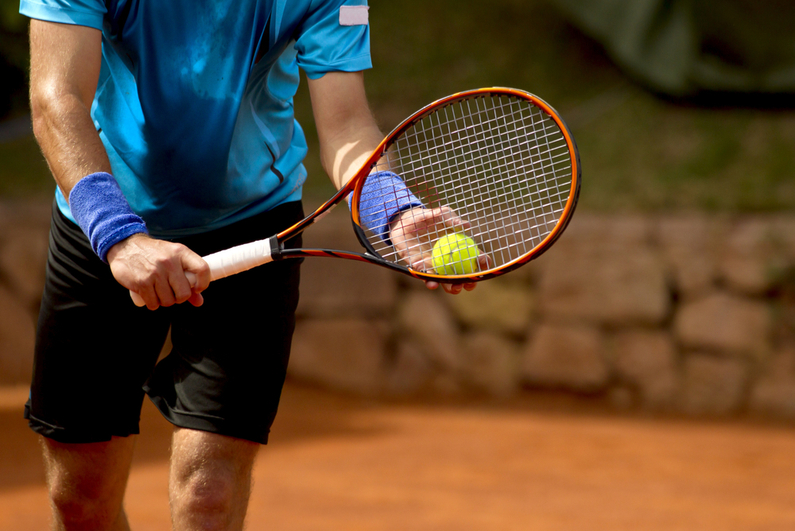 Tennis player preparing to serve.