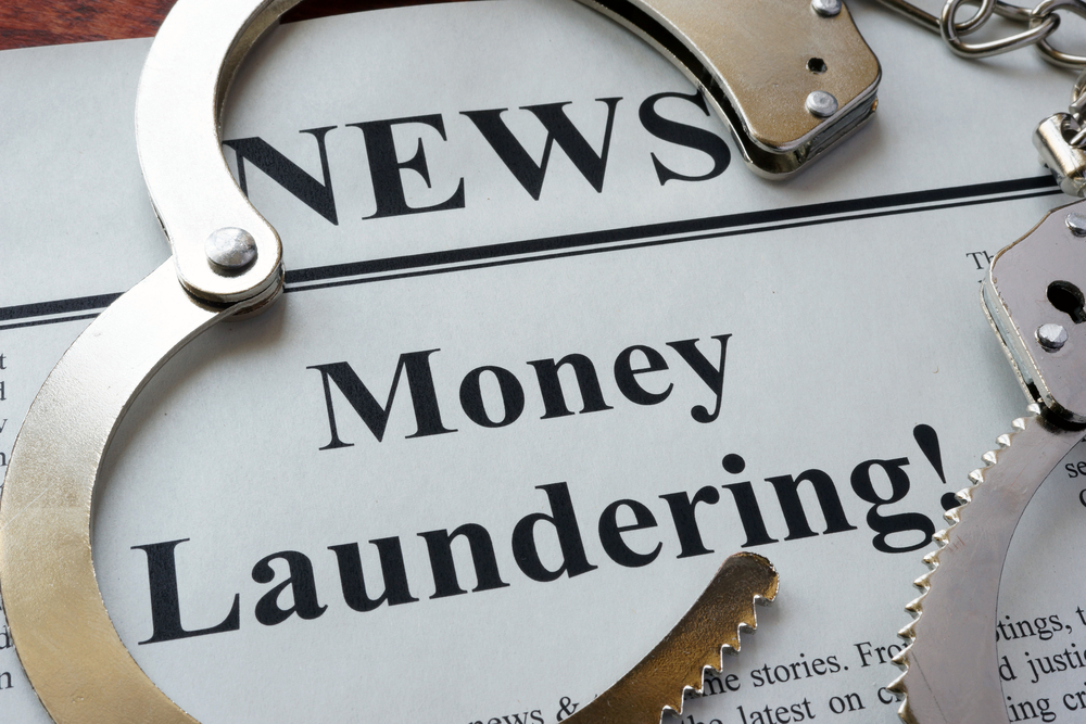 handcuffs on top of newspaper with money laundering headline