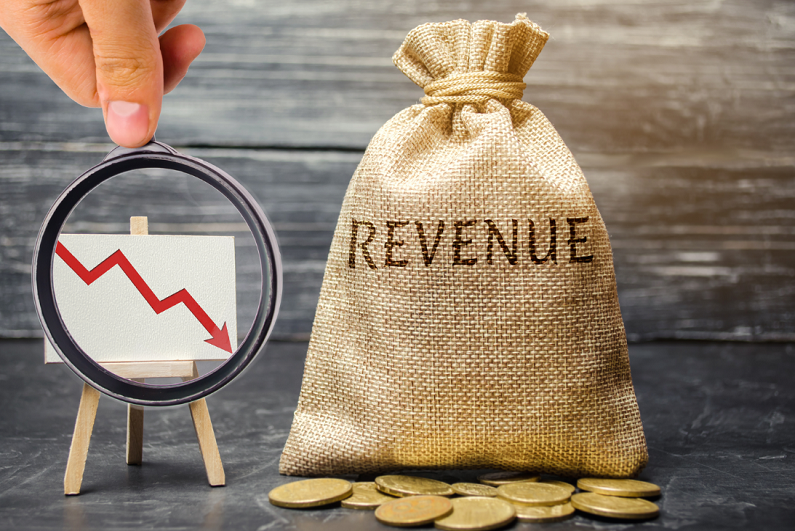 Money bag with the word revenue and a chart with downward trend.