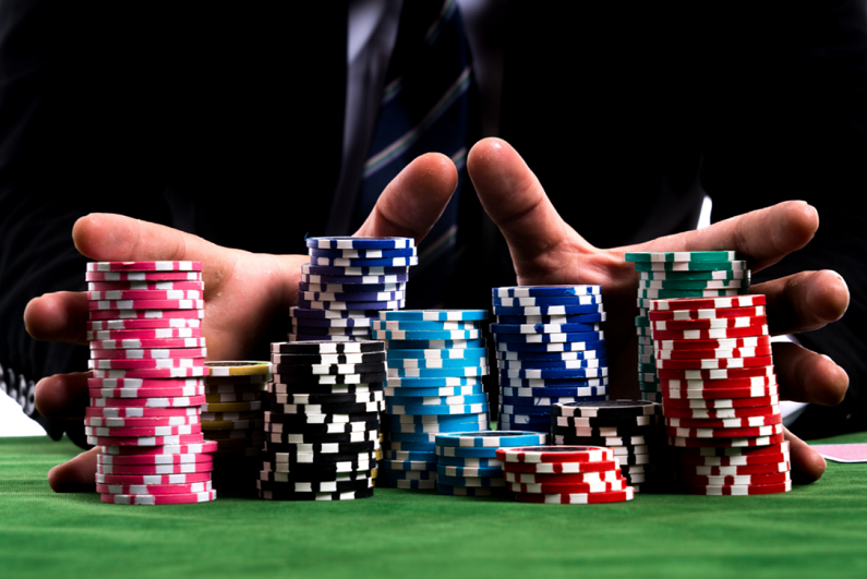 Poker player shoving all his chips into the pot