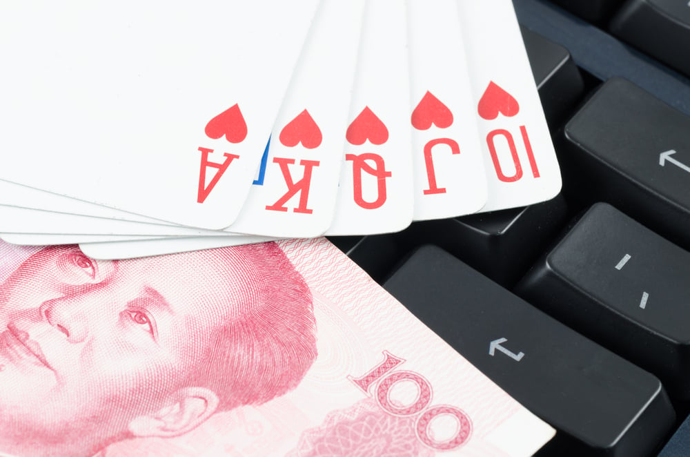 playing cards and Chinese yuan on computer keyboard