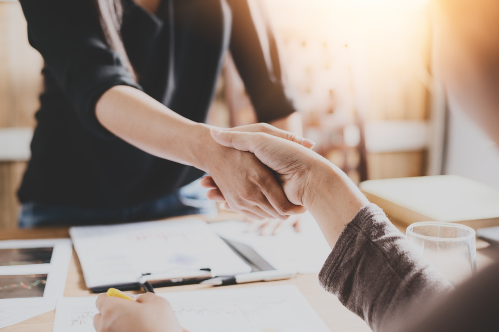 two businesswomen shaking hands in agreement