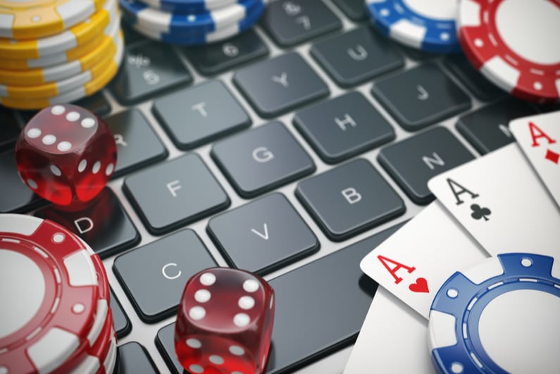 Dice, cards, and chips on a laptop keyboard