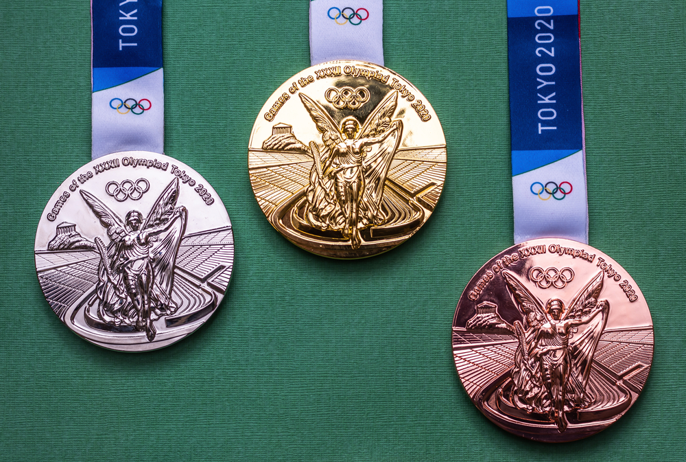 gold, silver, and bronze 2020 Tokyo Olympics medals against green background