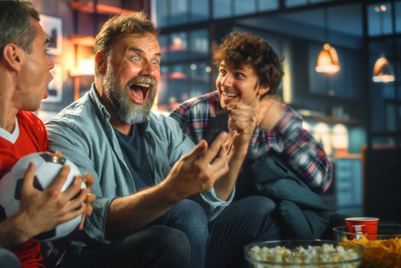 Three guys getting way too excited about winning a sports bet on their phone